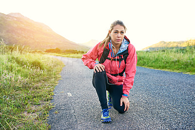 Buy stock photo Shot of a focused young woman out for a run on a cool morning