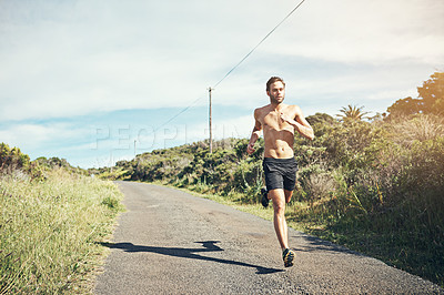 Buy stock photo Shot of a bare chested young man out for an early morning run