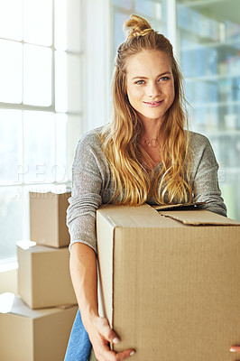 Buy stock photo Shot of a beautiful young woman carrying a box while moving house