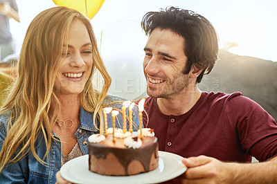 Buy stock photo Shot of an affectionate young couple celebrating a birthday with a chocolate cake