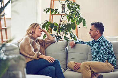 Buy stock photo Shot of an affectionate mature couple sitting on the sofa at home