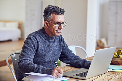 Buy stock photo Shot of a handsome and mature businessman working from home