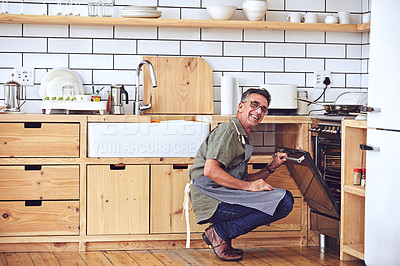 Buy stock photo Shot of a handsome and mature man cooking in the kitchen at home