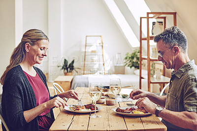 Buy stock photo Shot of an affectionate and mature couple enjoying a meal together