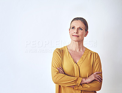Buy stock photo Shot of an attractive and mature woman looking thoughtful against a grey background