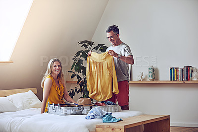 Buy stock photo Shot of an affectionate mature couple packing their bags for a holiday
