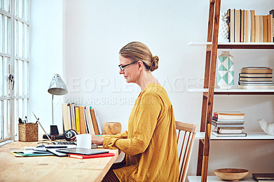 Buy stock photo Shot of an attractive and mature woman working on her laptop at home