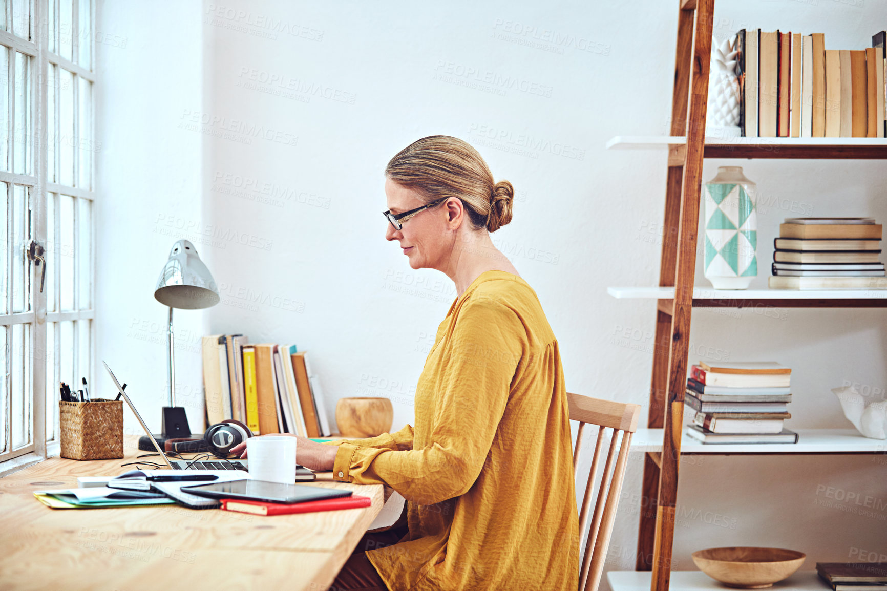 Buy stock photo Shot of an attractive and mature woman working on her laptop at home