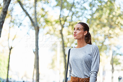 Buy stock photo Cropped shot of a young woman walking through the city