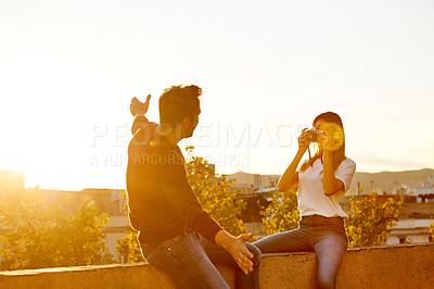Buy stock photo Shot of a young woman taking a photo of her boyfriend