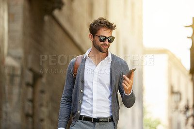 Buy stock photo Cropped shot of a handsome and stylish young man walking through the city