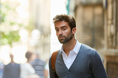 Buy stock photo Cropped shot of a handsome and stylish young man walking through the city