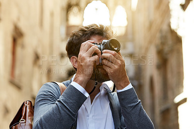 Buy stock photo Cropped shot of a stylish young male tourist taking photos of a foreign city