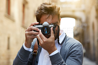 Buy stock photo Cropped shot of a stylish young male tourist taking photos of a foreign city