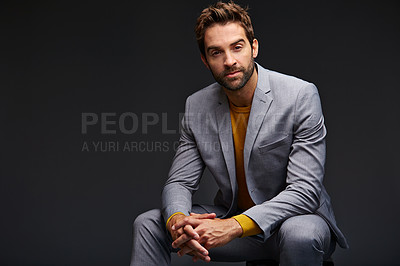 Buy stock photo Studio portrait of a handsome young man posing against a dark background
