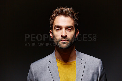 Buy stock photo Studio portrait of a handsome young man posing against a dark background