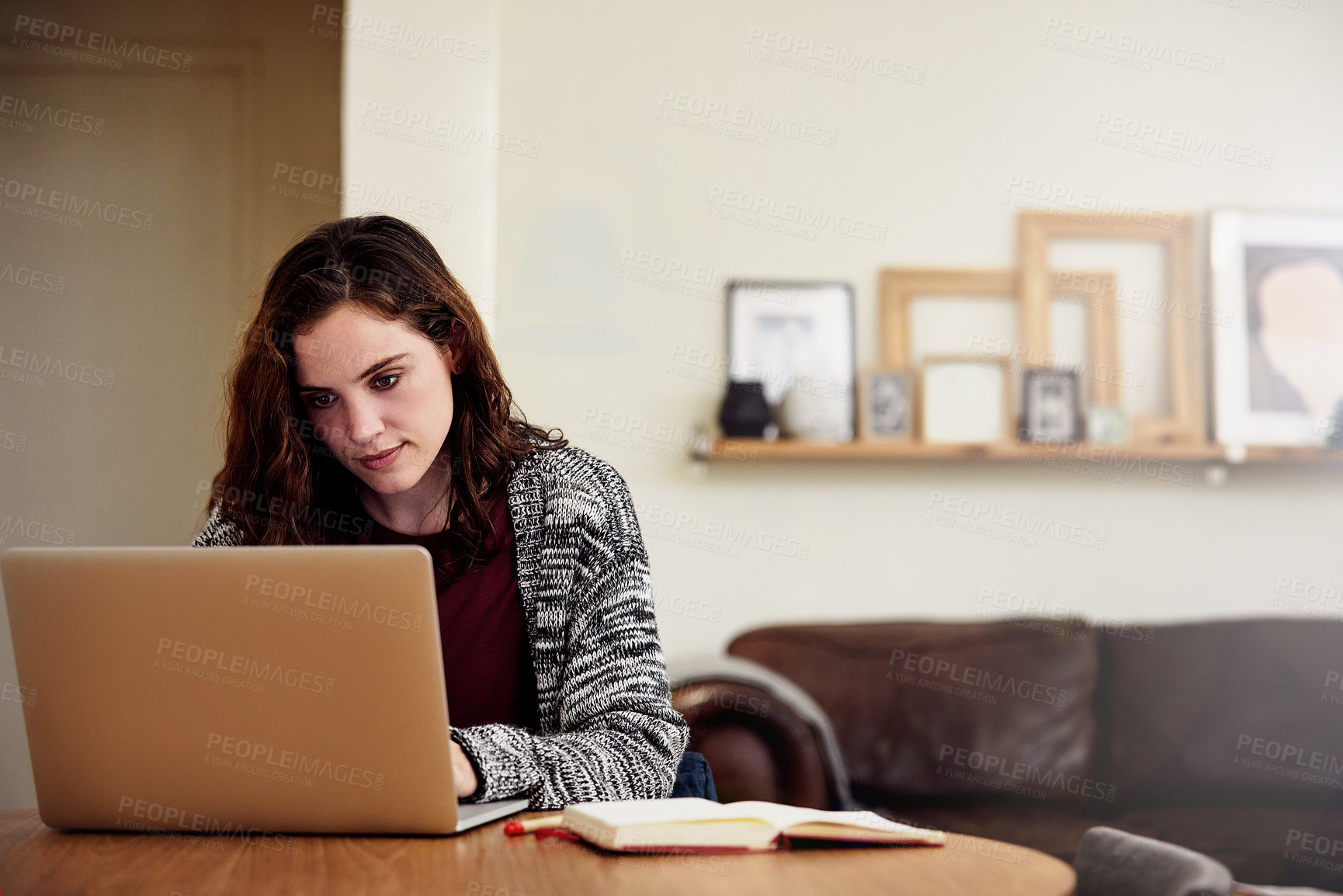 Buy stock photo Shot of an attractive young woman working on her laptop at home