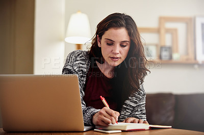 Buy stock photo Shot of an attractive young woman working on her laptop at home