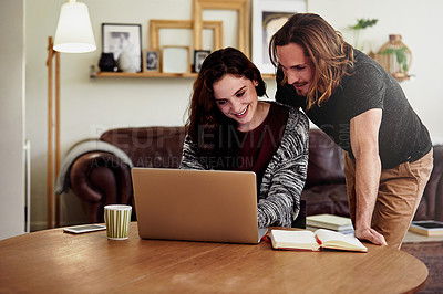 Buy stock photo Shot of a handsome young man watching his wife as she works from home
