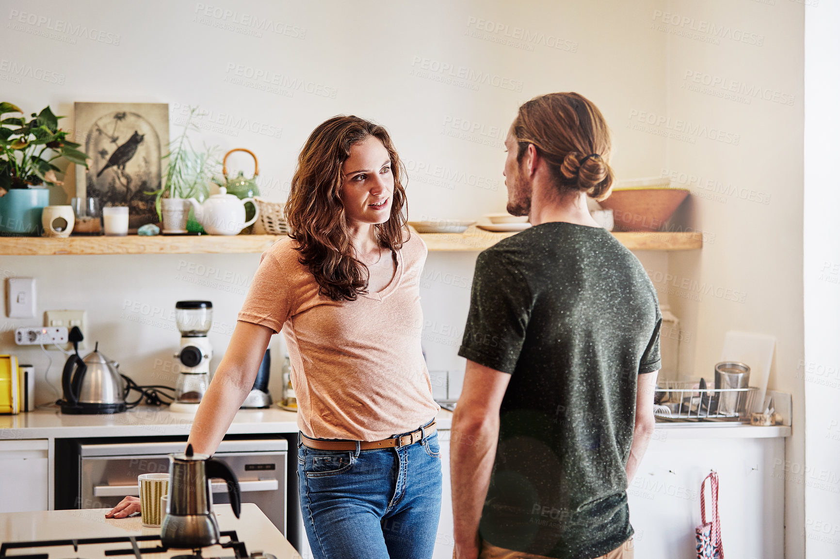 Buy stock photo Shot of an affectionate young couple having a conversation in the kitchen