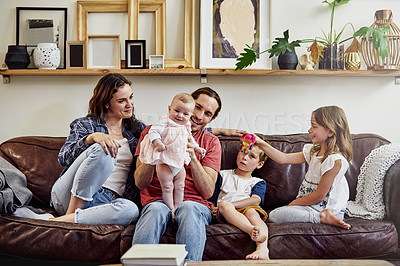 Buy stock photo Shot of a happy and loving young family sitting on the sofa at home