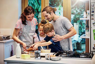 Buy stock photo Shot of a happy young family of four baking in the kitchen at home