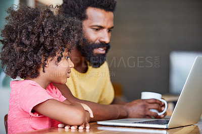 Buy stock photo Shot of a cheerful young father and son browsing on a digital tablet together while being seated at a table in their home