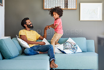 Buy stock photo Shot of a cheerful little boy trying to pull his father's arm to make him get up from a couch at home