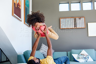 Buy stock photo Shot of a cheerful little boy getting picked up by his dad while lying down on a couch