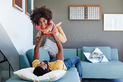 Buy stock photo Portrait of a cheerful little boy getting picked up by his dad while lying down on a couch