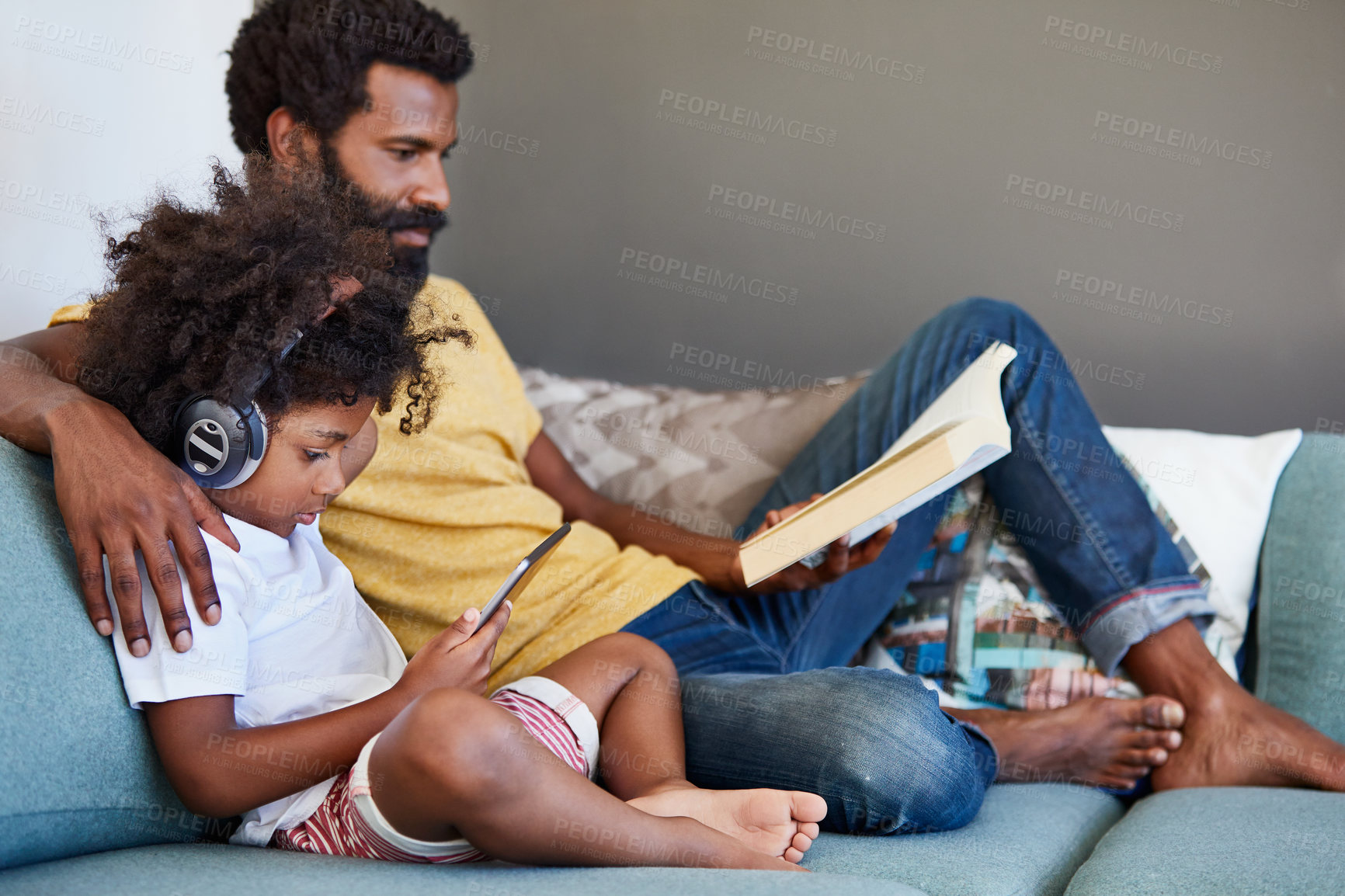 Buy stock photo Headphones, father and child with tablet, reading book and educational music video for bonding. Audio tech, parent care and boy watch cartoon in home, learning literature and African family relax