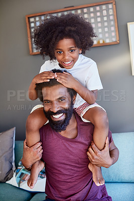 Buy stock photo Portrait of a cheerful little boy sitting on his dad's shoulders with his hands on his dad's head inside at home during the day