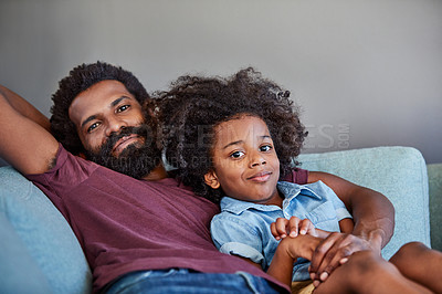 Buy stock photo Portrait of a cheerful father and son lying down and relaxing on the couch at home during the day