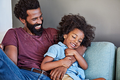 Buy stock photo Shot of a cheerful father and son lying down and relaxing on the couch at home during the day