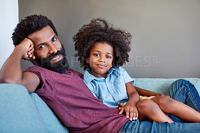 Buy stock photo Portrait of a cheerful father and son lying down and relaxing on the couch at home during the day