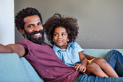 Buy stock photo Portrait of a cheerful father and son lying down and relaxing on the couch at home during the day