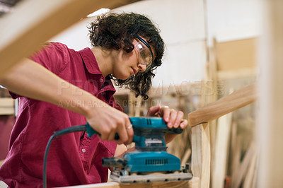 Buy stock photo Shot of a woman working with wood in a furniture manufacturing workshop