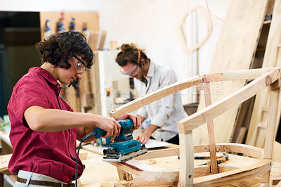 Buy stock photo Shot of two people working with wood in a furniture manufacturing workshop