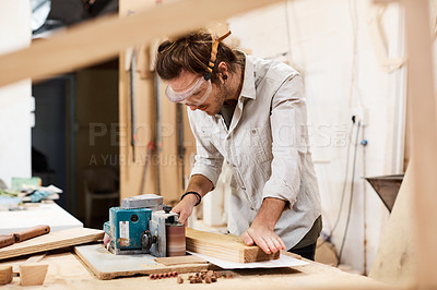 Buy stock photo Shot of a man working with wood in a furniture manufacturing workshop