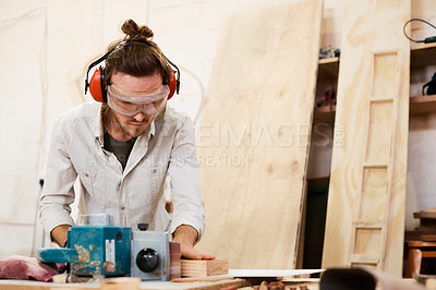 Buy stock photo Shot of a man working with wood in a furniture manufacturing workshop