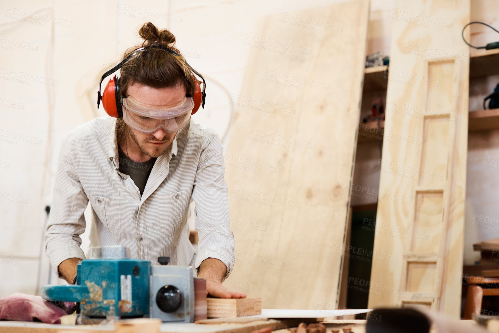 Buy stock photo Shot of a man working with wood in a furniture manufacturing workshop
