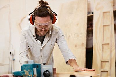 Buy stock photo Shot of a man working with wood in a furniture manufacturing workshop