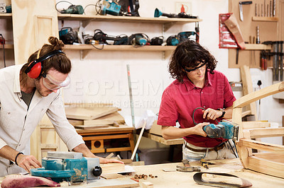 Buy stock photo Shot of two people working with wood in a furniture manufacturing workshop