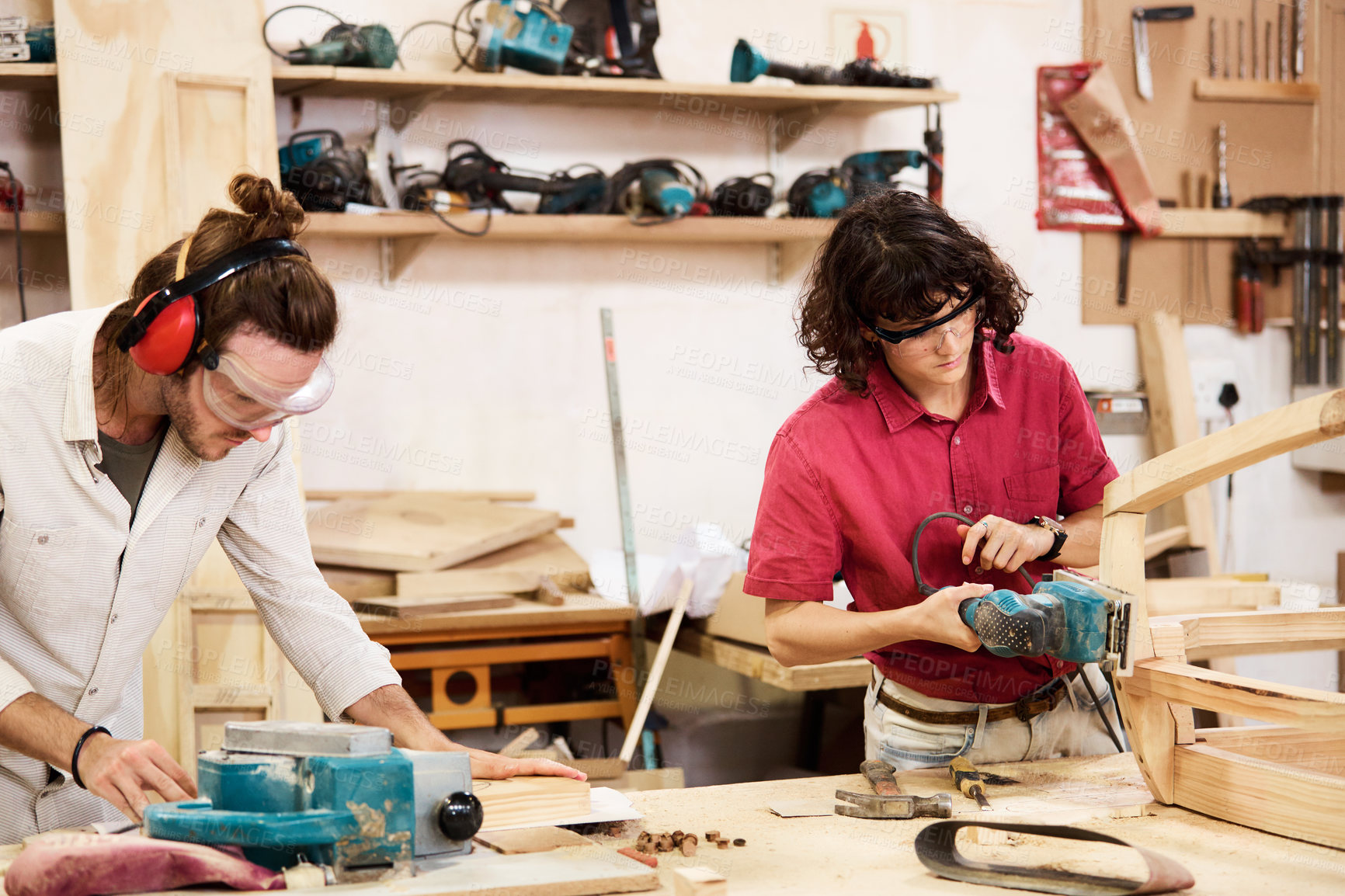 Buy stock photo Shot of two people working with wood in a furniture manufacturing workshop