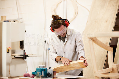 Buy stock photo Shot of a man working with wood in a furniture manufacturing workshop