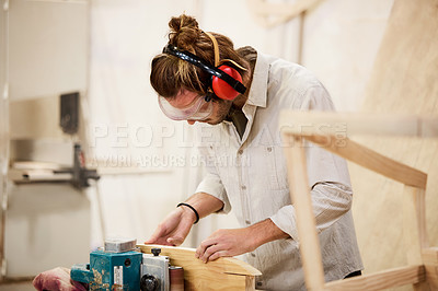 Buy stock photo Shot of a man working with wood in a furniture manufacturing workshop