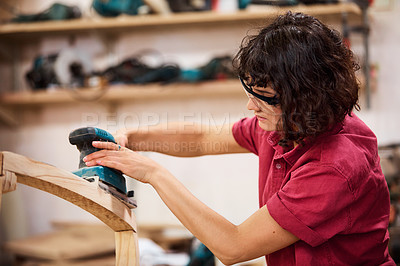 Buy stock photo Shot of a woman working with wood in a furniture manufacturing workshop