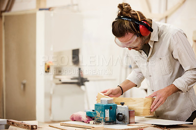 Buy stock photo Shot of a man working with wood in a furniture manufacturing workshop