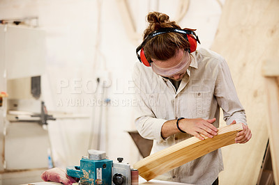 Buy stock photo Shot of a man working with wood in a furniture manufacturing workshop