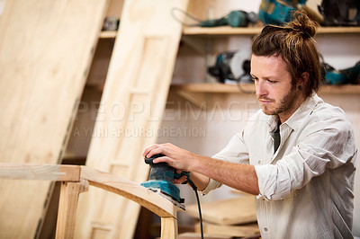 Buy stock photo Shot of a man working with wood in a furniture manufacturing workshop